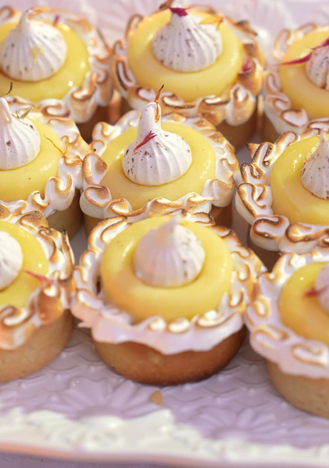 Tartelettes au citron meringuées sur un buffet de desserts